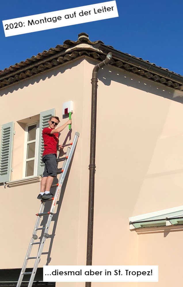 Ein Techniker auf einer Leiter montiert eine Außensirene an der Fassade einer Villa in St. Tropez, 2020.
