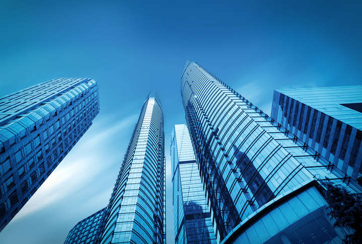 Hohe Firmengebäude ragen in einen blauen Himmel auf